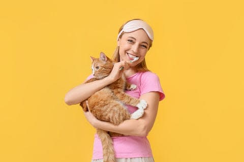 a woman in a pink shirt holding a cat