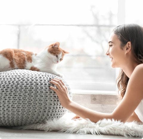 a woman laying on a floor next to a cat