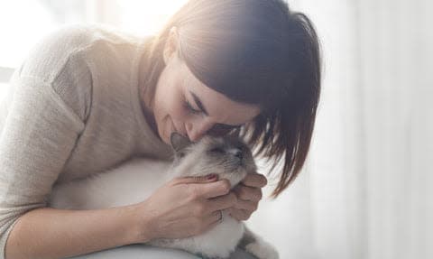 a woman holding a cat in her arms