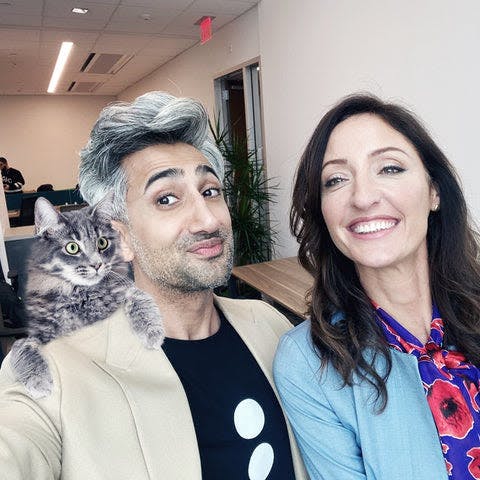 a man and a woman taking a selfie with a cat